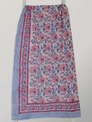 Cherry China cotton sarong hanging full length, showing its ivory ground with raspberry and blue florals