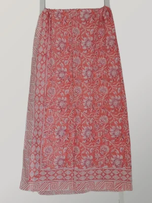 Coral Crush cotton sarong hanging full length, showing its vibrant coral and ivory floral print