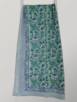 Mint Julep cotton sarong hanging full length, showing its fresh mint and teal floral print with blue borders
