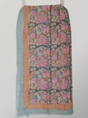 Peach Melba cotton sarong hanging full length, showing its blush pink and apricot floral print with aqua borders