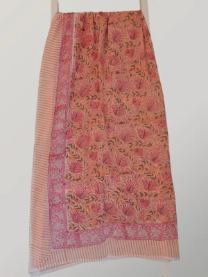 Peachy Keen cotton sarong hanging full length, showing its warm peach, coral and raspberry floral print