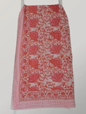 Pink Grapefruit cotton sarong hanging full length, showing its vibrant coral pink and ivory floral print
