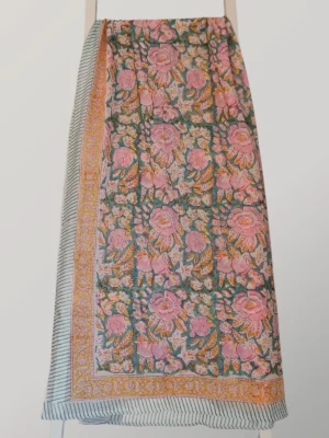 Tutti Frutti cotton sarong hanging full length, showing its multicoloured print in aqua, blush, mustard and green